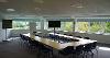 One half of the Taw and Torridge meeting room, configured with tables, chairs, flipcharts and two large television screens for presentation use.