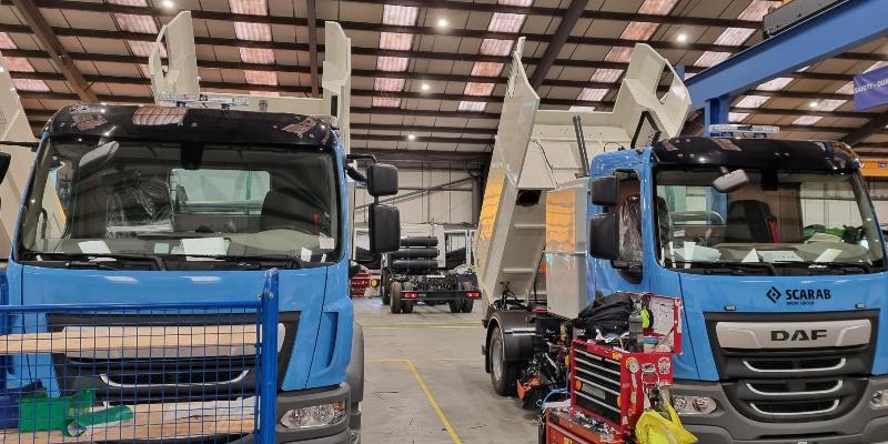 Photo of two blue lorries in a warehouse 