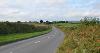 DCA 63: View north-west along the A3124 north of Beaford. Large farm with new agricultural barns visible as well as a traditional thatched cottage.