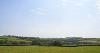 DCA 64: Three wind turbines east of Tetcott visible in the skyline, partially interrupting the distant view of Dartmoor.