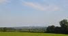 DCA 65: A distant view of Dartmoor from south of Shebbear, across farmland with a dense hedgerow network and extensive areas of woodland.