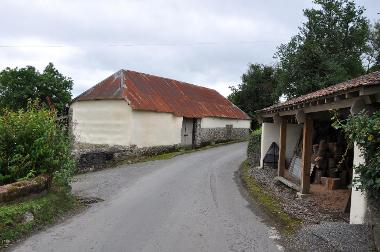 LCT 3G Isolated farm building on winding lane with characteristic local vernacular of cream/whitewash and exposed stone.