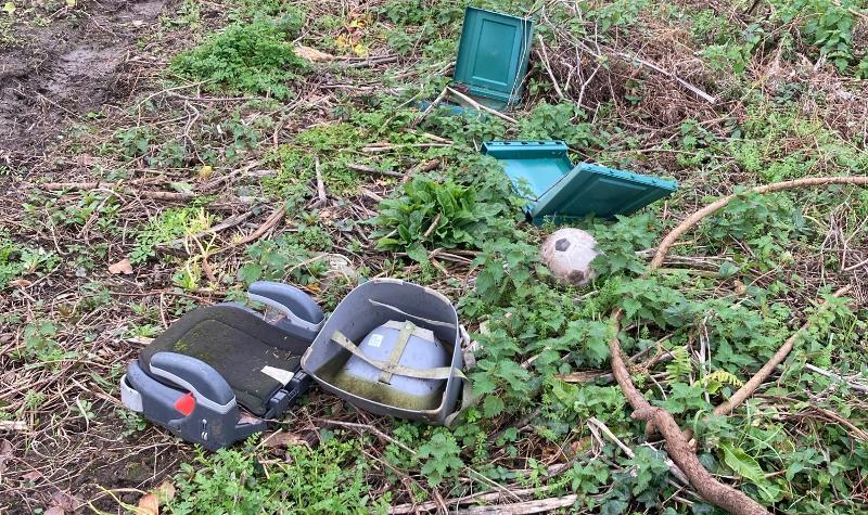 Items that have been thrown and dumped, including a children's car seat