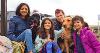 Image of multiple people smiling for the camera with a couple of dogs