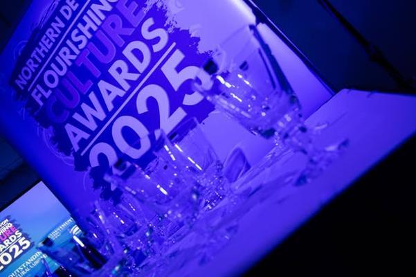 Photo of glasses in front of a Flourishing Culture Awards poster