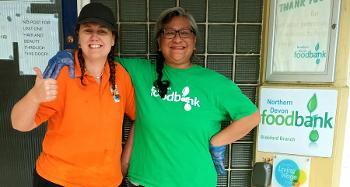 Two women posing for a photo, one doing a thumbs up.