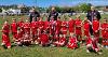 Photo of a football team from Bideford AFC, consisting of children wearing red football shirts and holding a trophy. 