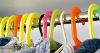 Picture of the tops of multiple coloured clothes hangers, hanging on a clothes rail.