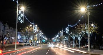 Picture of the road along Bideford Quay at night time, with car lights and the christmas lights