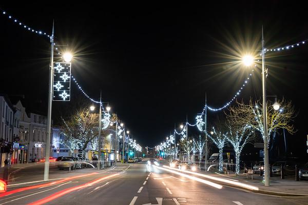 Picture of the road along Bideford Quay at night time, with car lights and the christmas lights