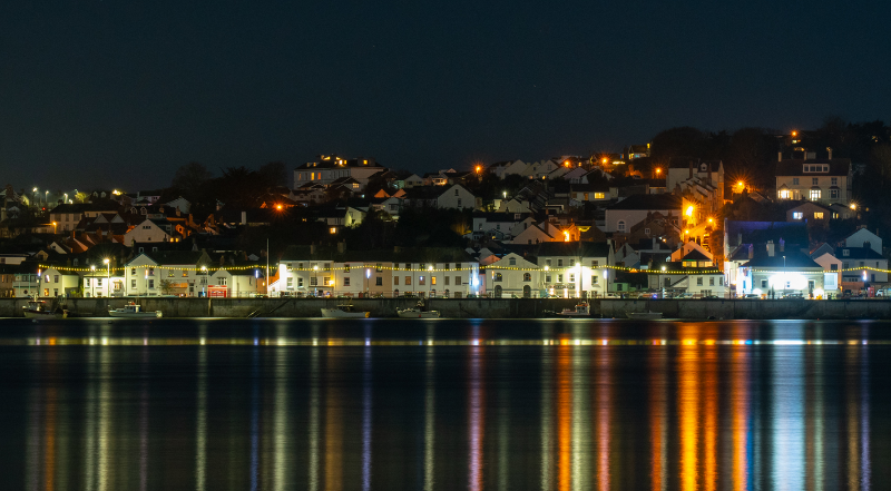 A photo of Appledore at night with the lights reflecting on the water