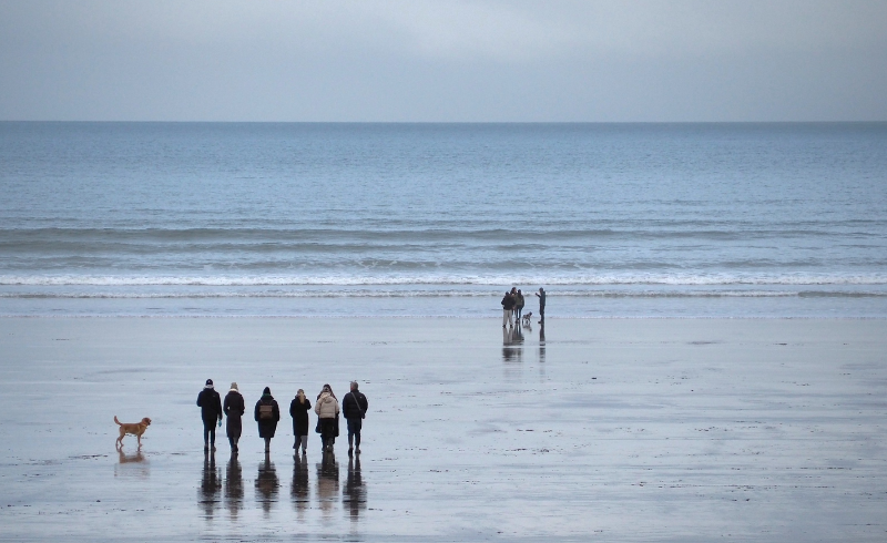 Group of people walking along the beach 