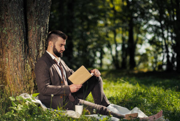 Great Place to work, man sat outside under a tree reading 